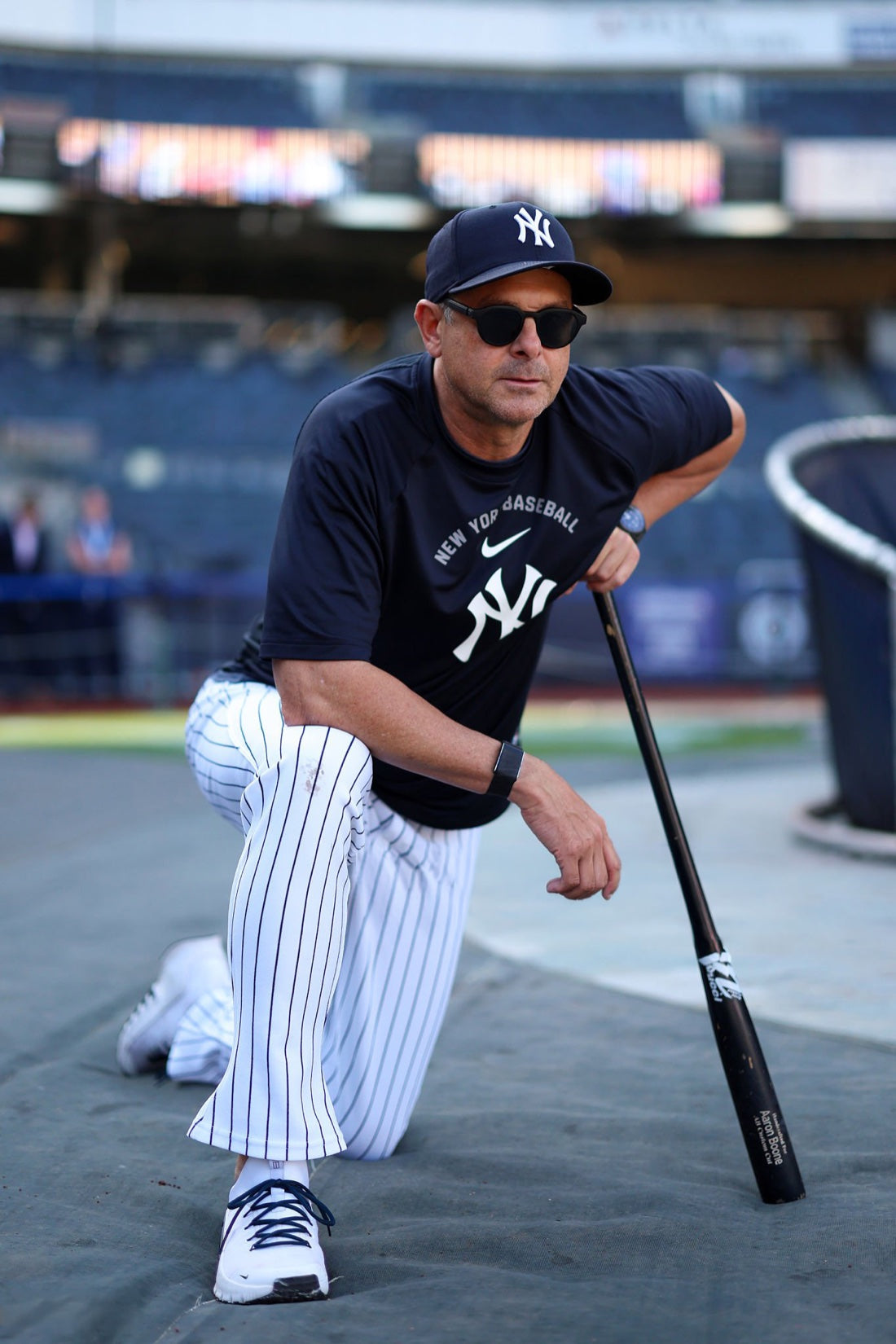 Aaron Boone kneeling with his bat at Yankee Stadium wearing basn5 highway 1 sunglasses