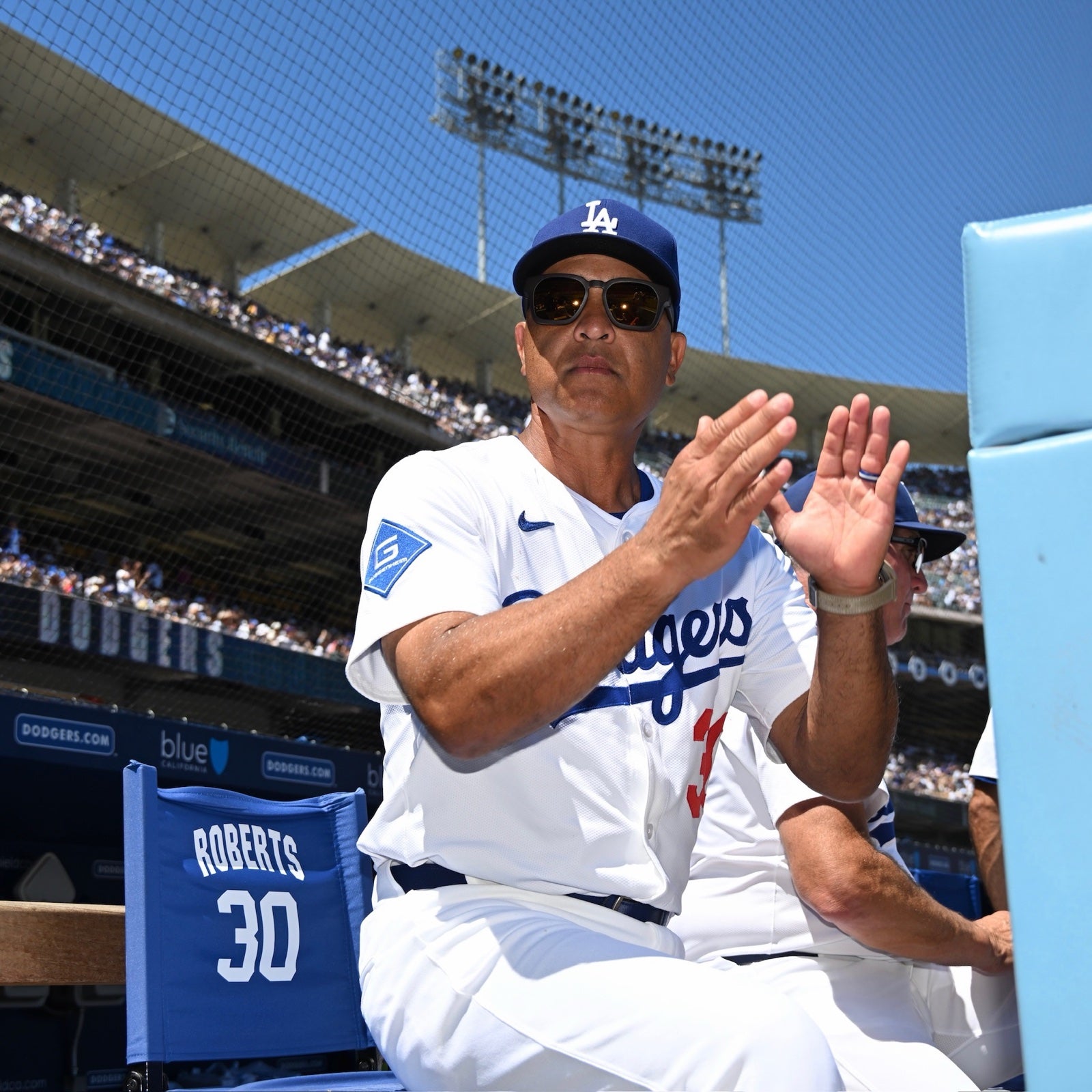 Dave Roberts in the basn5 davenport applauding at Dodger Stadium