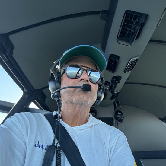 Cam Lewis in the cockpit of a plane, wearing Fort Point