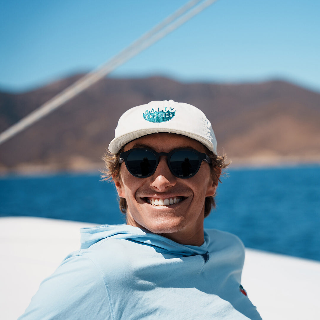 On a catamaran with mountains behind, wearing basn5 Highway 1